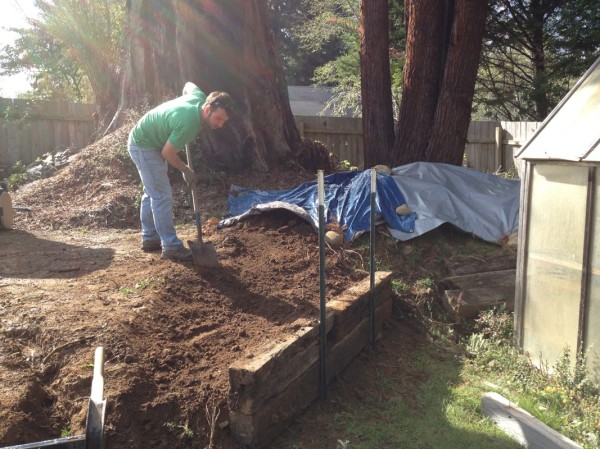 Jesse shoveling dirt toward the new retaining wall