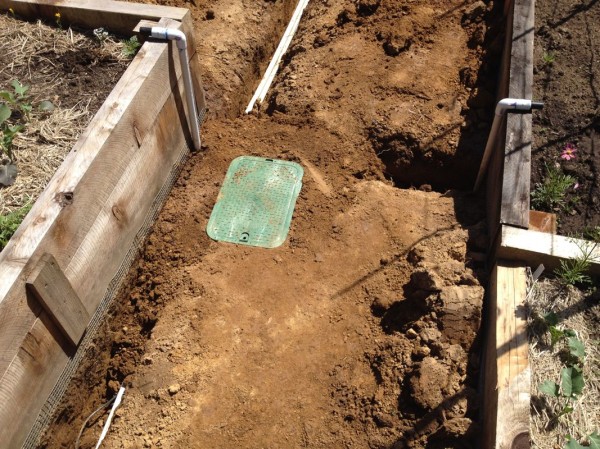 Here you can see the 1" and 3/4" lines inside the open trench, as well as the access point for the new garden station (the old garden has a similar one)